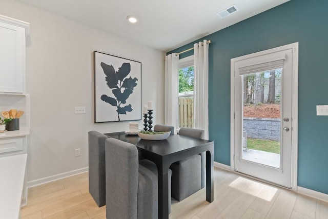 dining room featuring light wood finished floors, baseboards, and recessed lighting