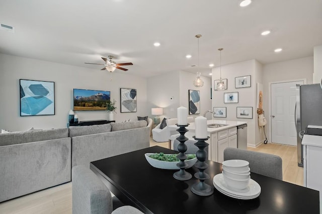 dining space with light wood-type flooring, a ceiling fan, and recessed lighting