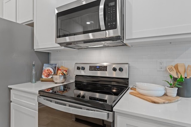 kitchen with stainless steel appliances, white cabinetry, tasteful backsplash, and light countertops