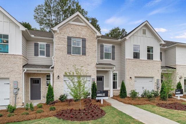 townhome / multi-family property with a garage, board and batten siding, and brick siding