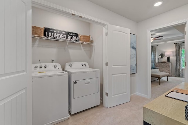 laundry room featuring light colored carpet, separate washer and dryer, a ceiling fan, and baseboards