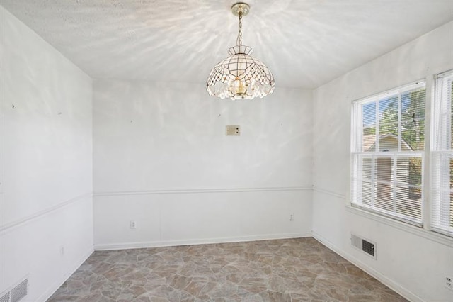 spare room with an inviting chandelier