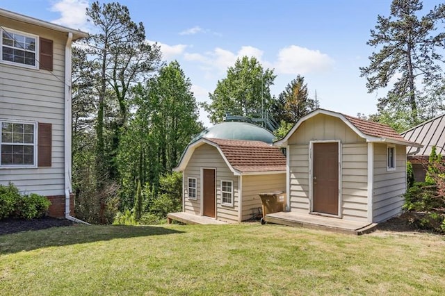 back of property featuring a lawn and a shed