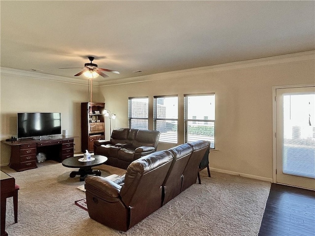 living area featuring ornamental molding, a ceiling fan, and baseboards