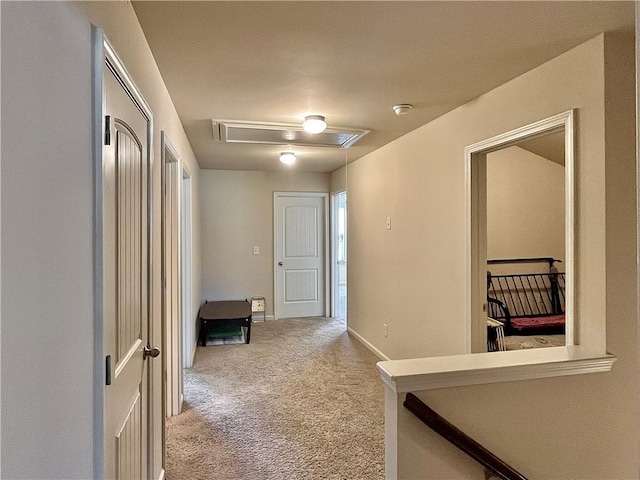 hall featuring carpet floors, attic access, and baseboards