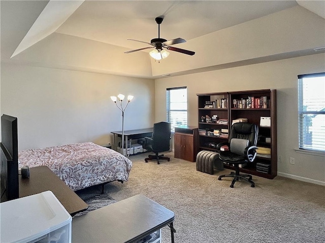 bedroom with ceiling fan, carpet floors, a tray ceiling, and baseboards