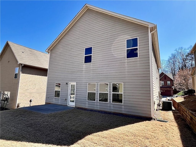 back of property with a lawn, a patio area, and cooling unit