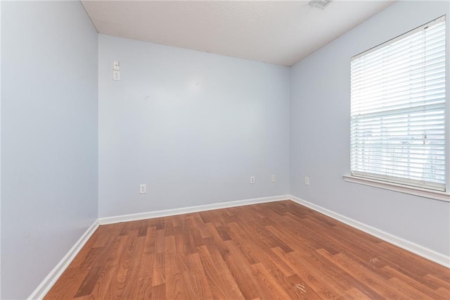 empty room featuring wood finished floors and baseboards