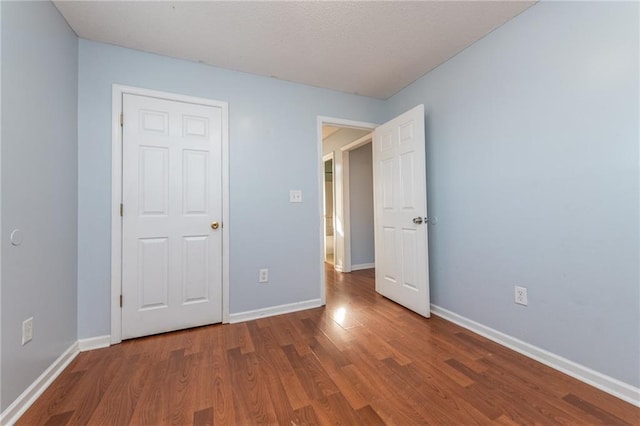 unfurnished bedroom with baseboards and wood finished floors