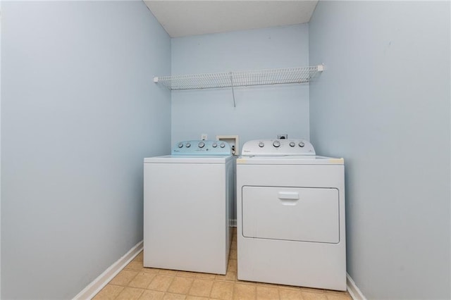 clothes washing area featuring laundry area, separate washer and dryer, baseboards, and light floors