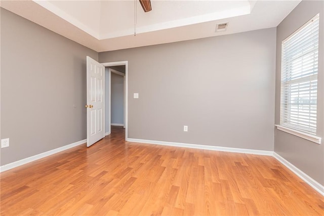 empty room with visible vents, baseboards, light wood-style flooring, and a ceiling fan