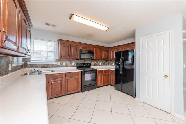 kitchen with light tile patterned floors, visible vents, decorative backsplash, black appliances, and light countertops