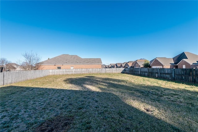 view of yard with a fenced backyard and a residential view