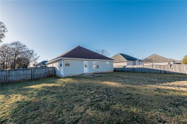 rear view of property with a lawn and a fenced backyard