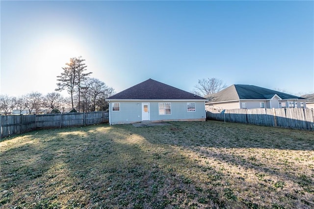 back of property with a lawn and a fenced backyard