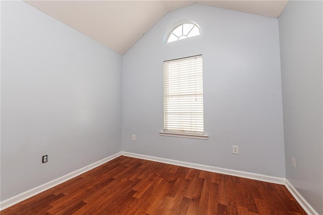 empty room with baseboards, wood finished floors, and vaulted ceiling