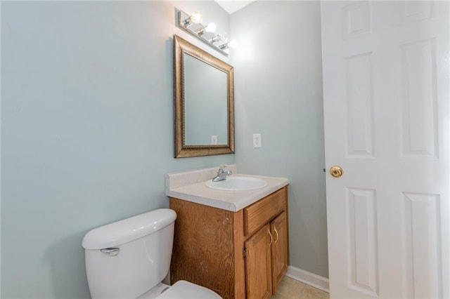 half bath featuring baseboards, toilet, and vanity