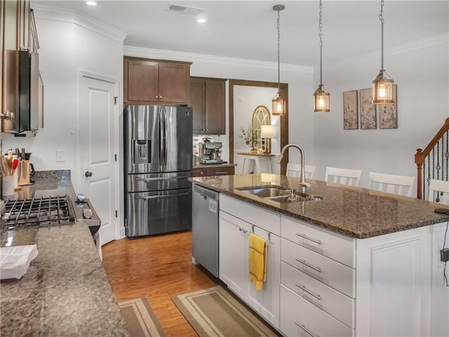 kitchen featuring white cabinetry, sink, a kitchen island with sink, stainless steel appliances, and light wood-type flooring