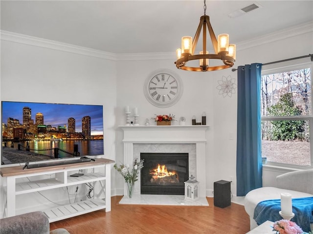 living room featuring wood-type flooring, ornamental molding, and a high end fireplace