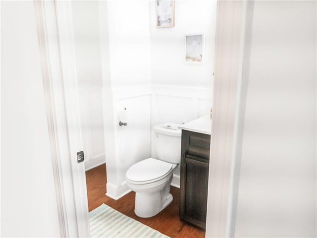 bathroom with hardwood / wood-style flooring, vanity, and toilet