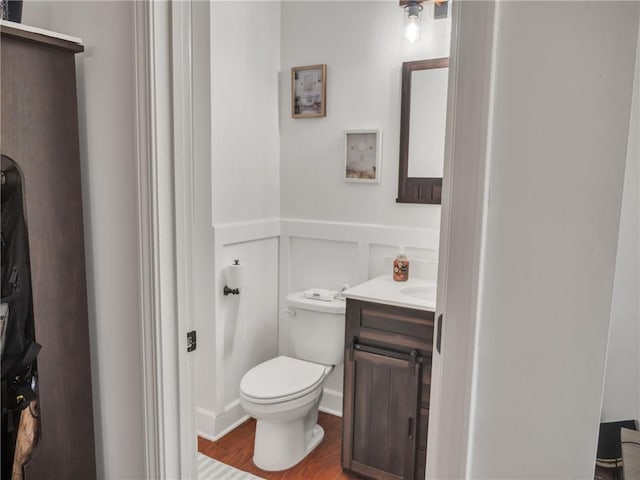 bathroom featuring vanity, wood-type flooring, and toilet