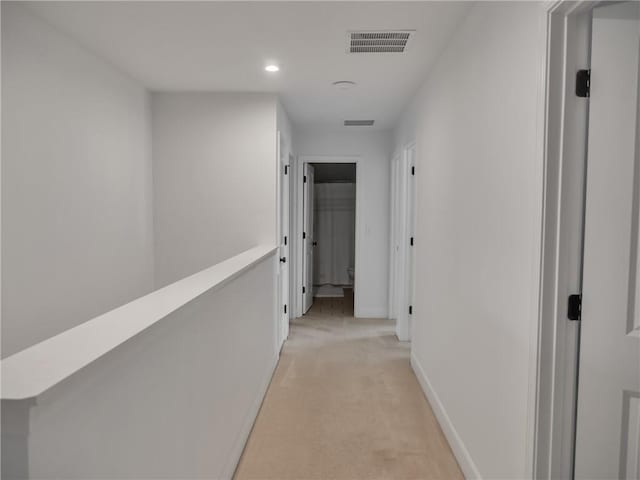 hallway featuring light colored carpet