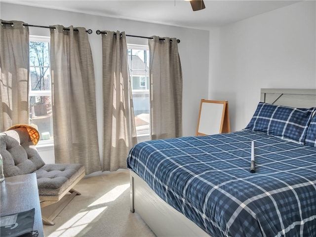 carpeted bedroom with multiple windows and ceiling fan