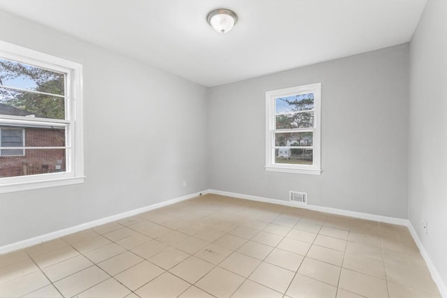 unfurnished room featuring light tile patterned floors and a wealth of natural light