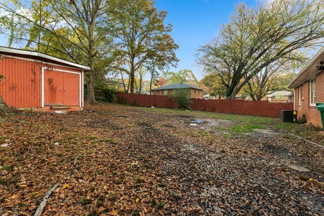 view of yard featuring central air condition unit and a storage shed