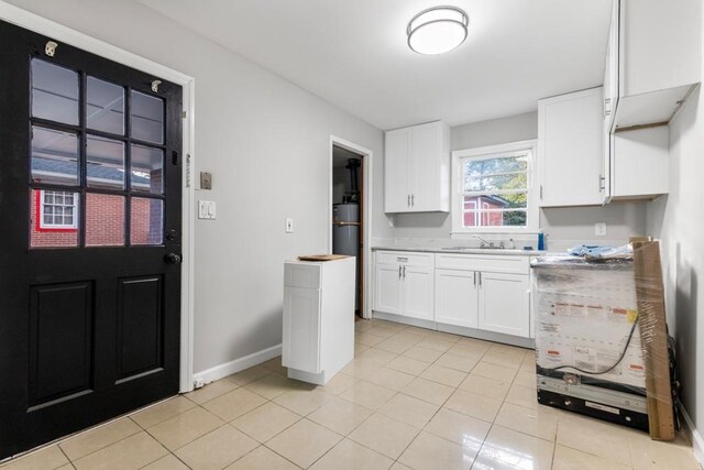 kitchen with sink, white cabinetry, and light tile patterned flooring