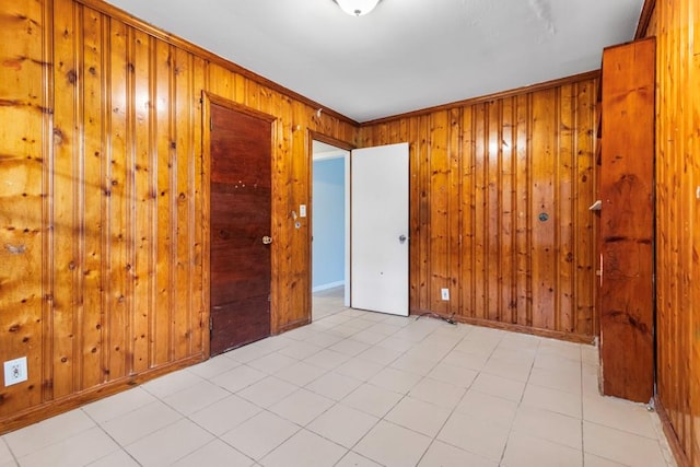 empty room featuring wooden walls and crown molding