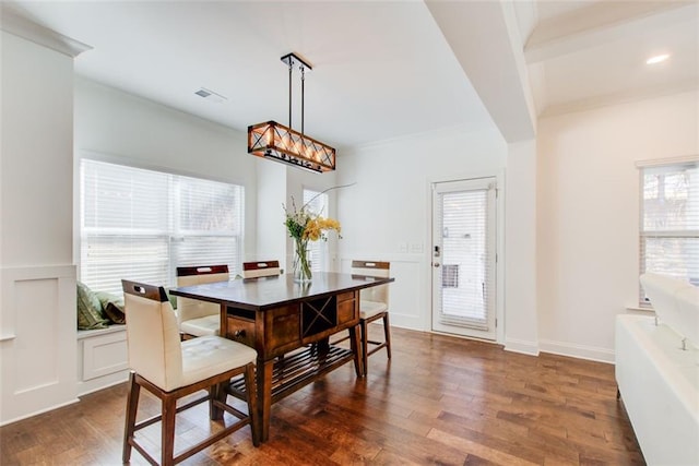 dining room featuring dark hardwood / wood-style flooring, crown molding, and a notable chandelier