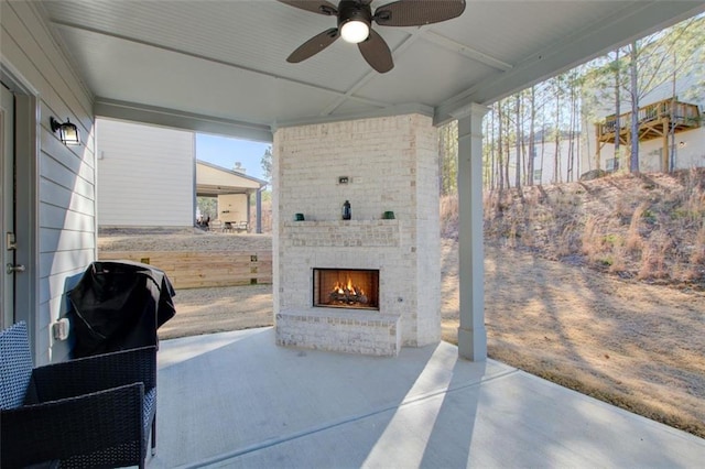 view of patio with an outdoor brick fireplace and ceiling fan