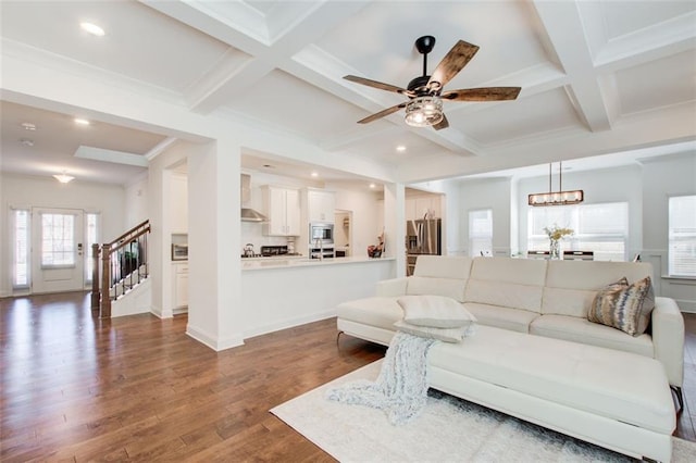 living room featuring beamed ceiling, dark hardwood / wood-style floors, ornamental molding, ceiling fan, and coffered ceiling