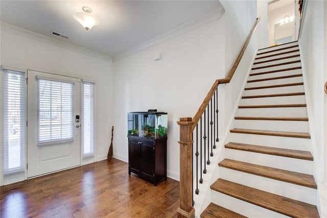 foyer entrance with crown molding and dark wood-type flooring