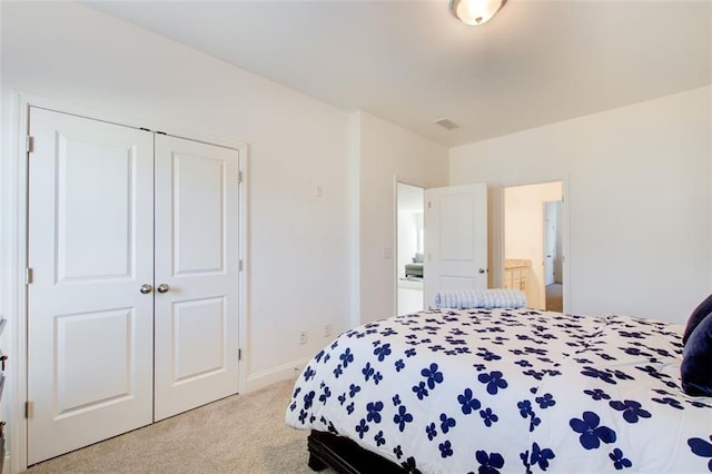 carpeted bedroom with a closet and ensuite bathroom