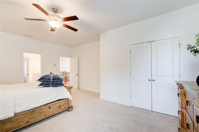 bedroom featuring light colored carpet, a closet, and ceiling fan