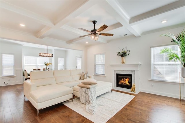 living room featuring coffered ceiling, a healthy amount of sunlight, and beam ceiling