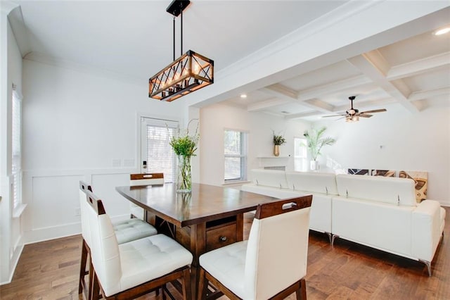 dining space featuring crown molding, ceiling fan, beam ceiling, dark hardwood / wood-style floors, and coffered ceiling