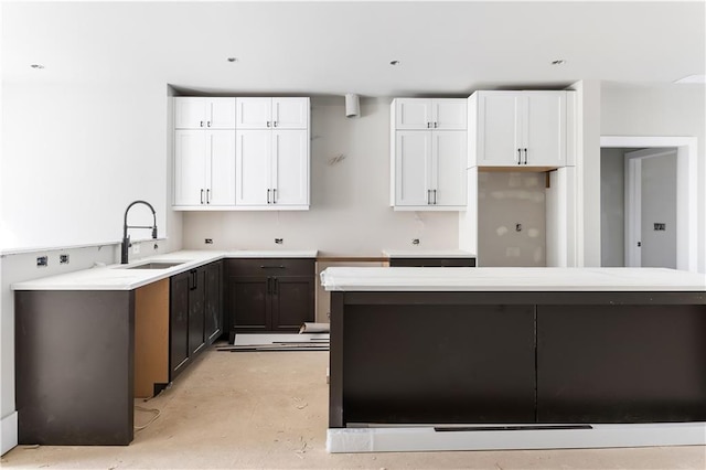 kitchen featuring white cabinetry, sink, and dark brown cabinetry