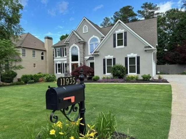 traditional-style house with a front yard and fence