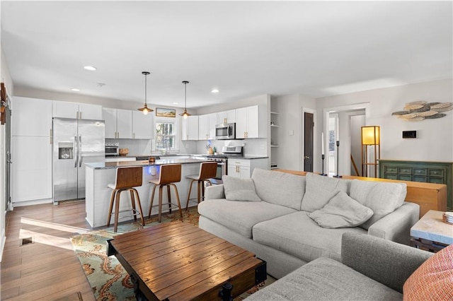 living room featuring light wood finished floors and recessed lighting