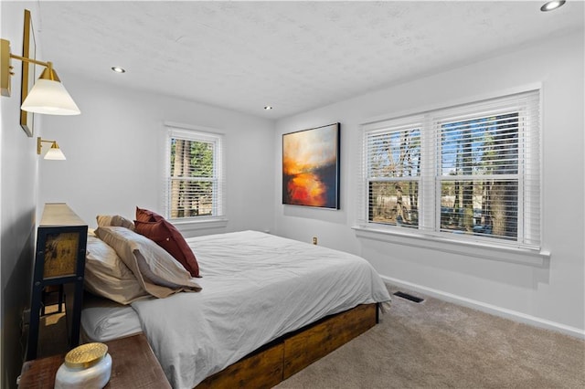 carpeted bedroom featuring baseboards, visible vents, and recessed lighting