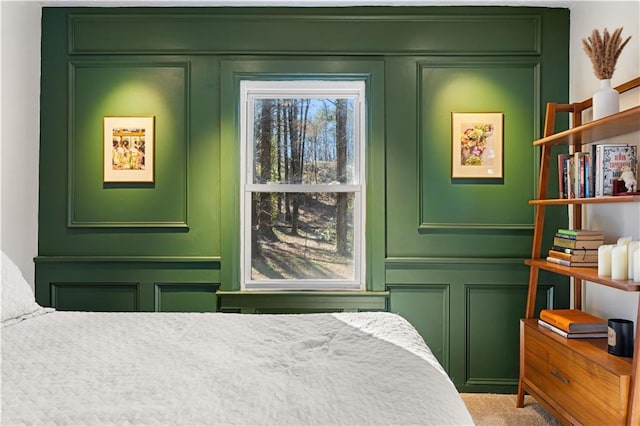 bedroom with carpet floors and a decorative wall