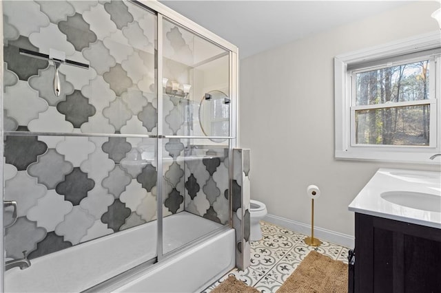 full bathroom with enclosed tub / shower combo, tile patterned flooring, toilet, a sink, and baseboards