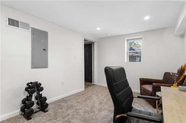 office area with carpet floors, baseboards, electric panel, and visible vents