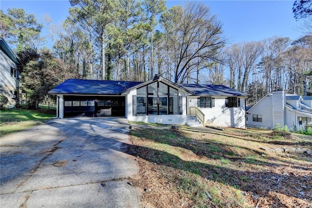 ranch-style home featuring an attached garage and driveway