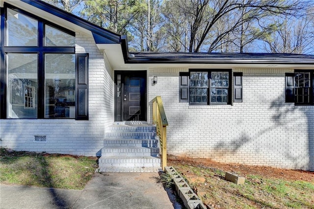 doorway to property featuring brick siding