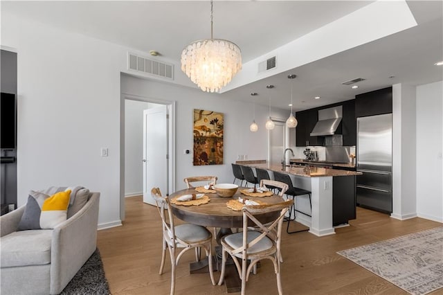 dining room with dark hardwood / wood-style floors, a chandelier, and sink