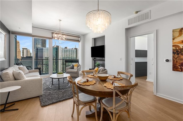 3325 Piedmont Rd NE Unit 2407, Atlanta, GA 30305 - dining space with a chandelier, plenty of natural light, light wood-style flooring, and visible vents